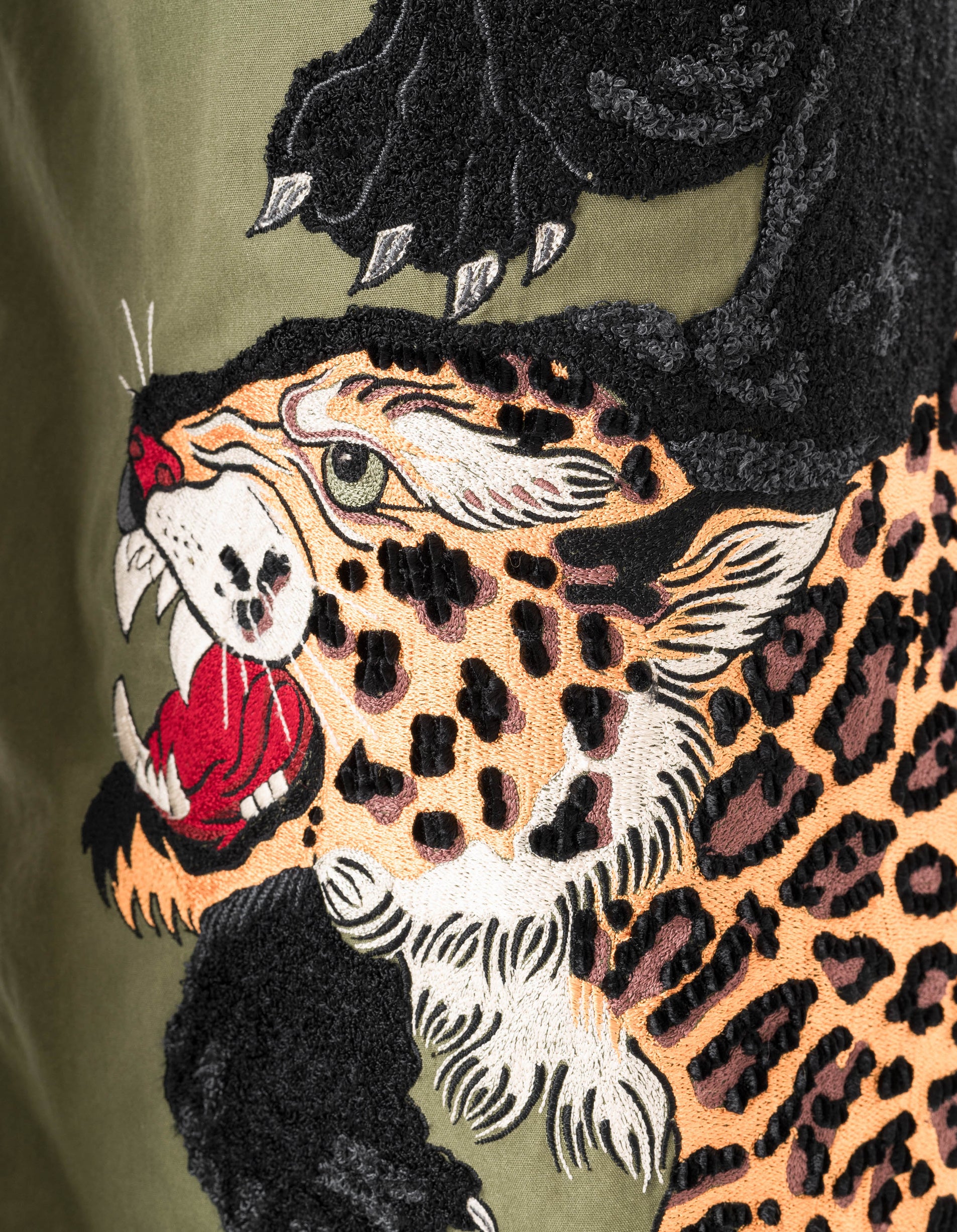 Embroidered design of a panther with a leopard on a green background