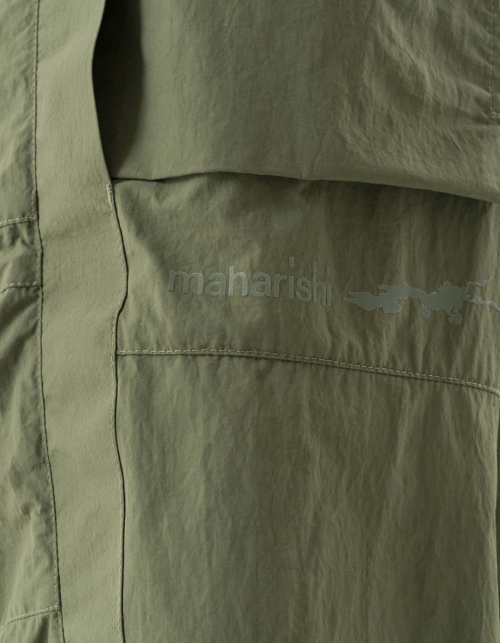 Close-up of green pants with 'maharisil' branding on a plain background