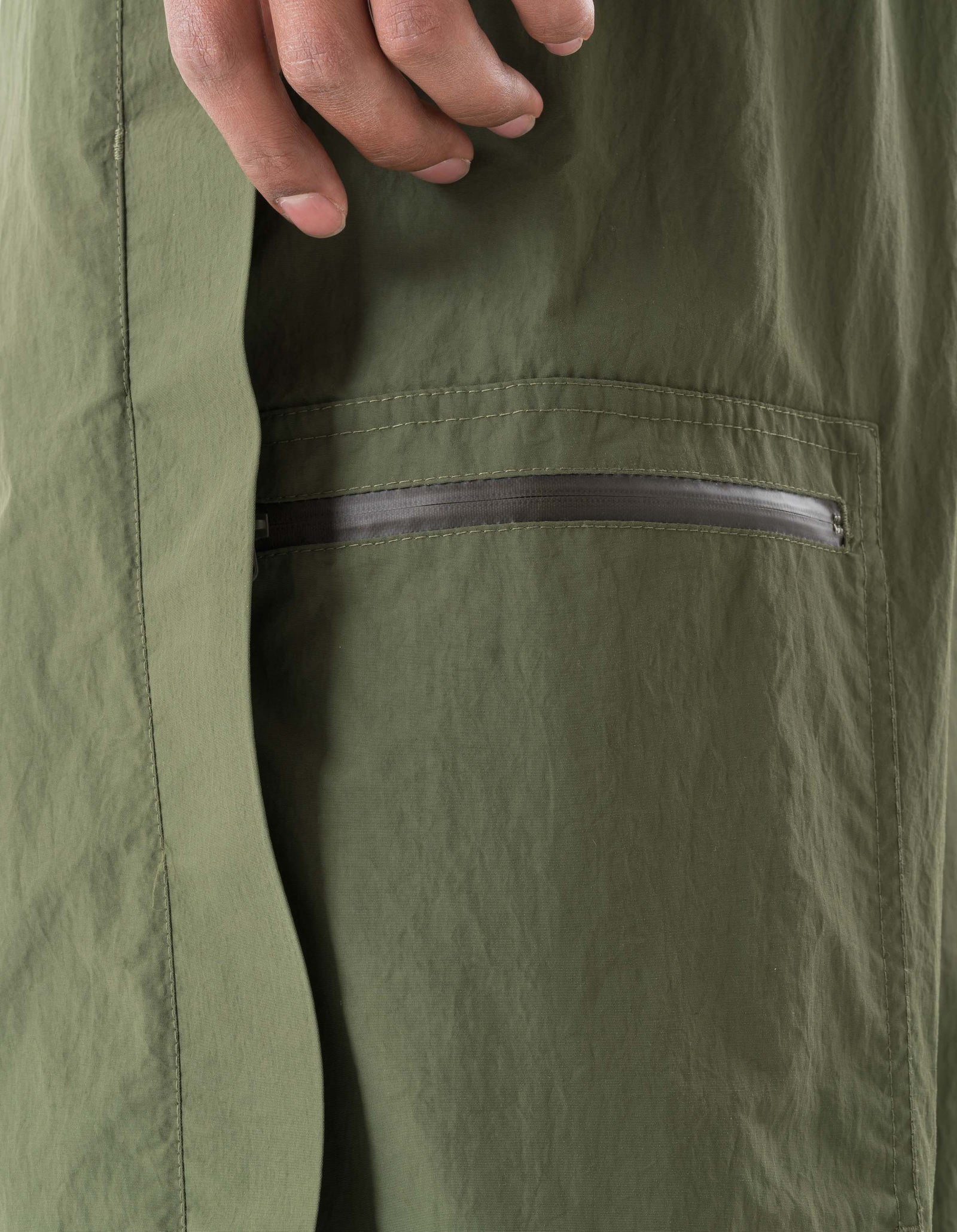 Close-up of green pants with a zipper detail